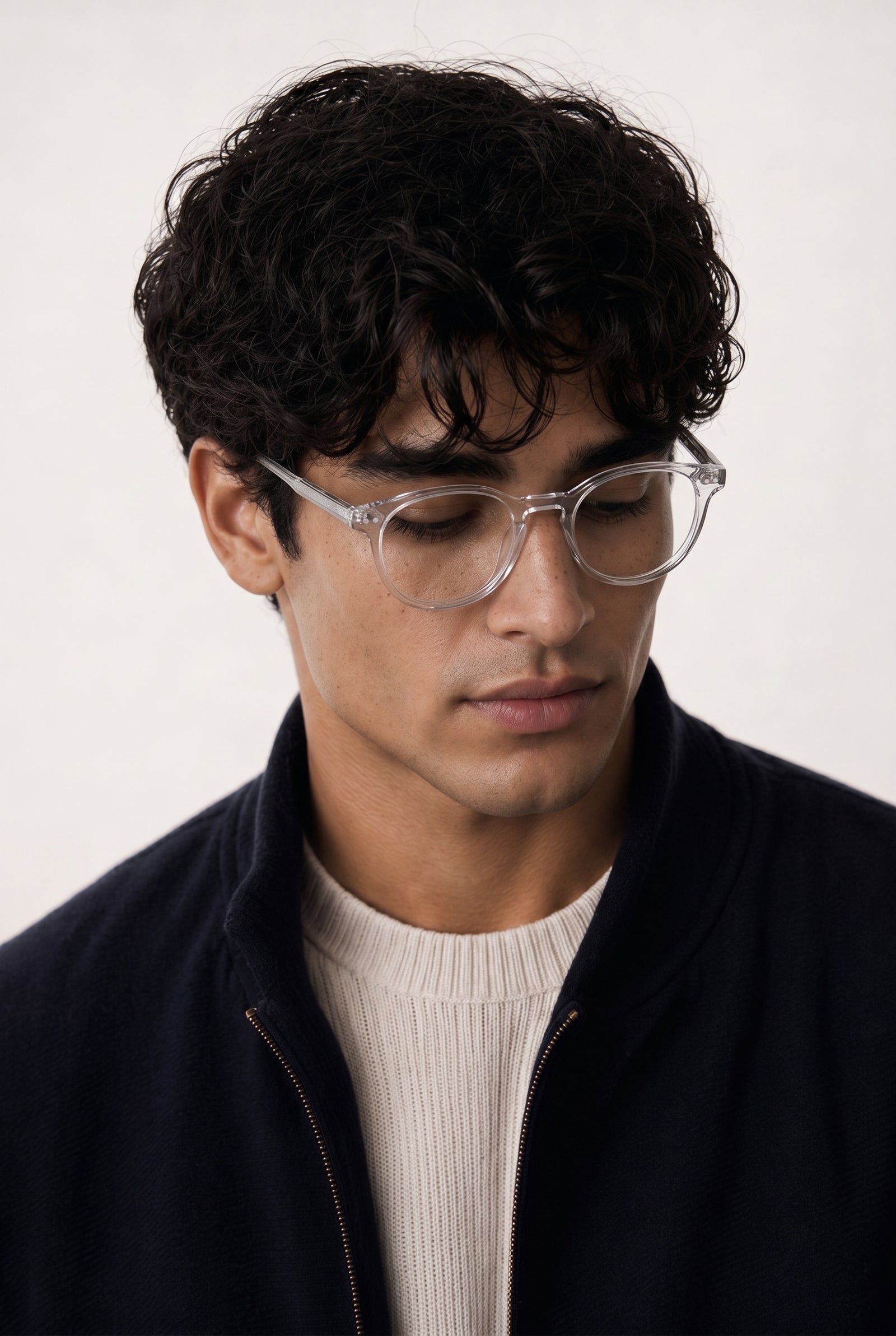 Man wearing blue light glasses SOL and a dark jacket against a white background