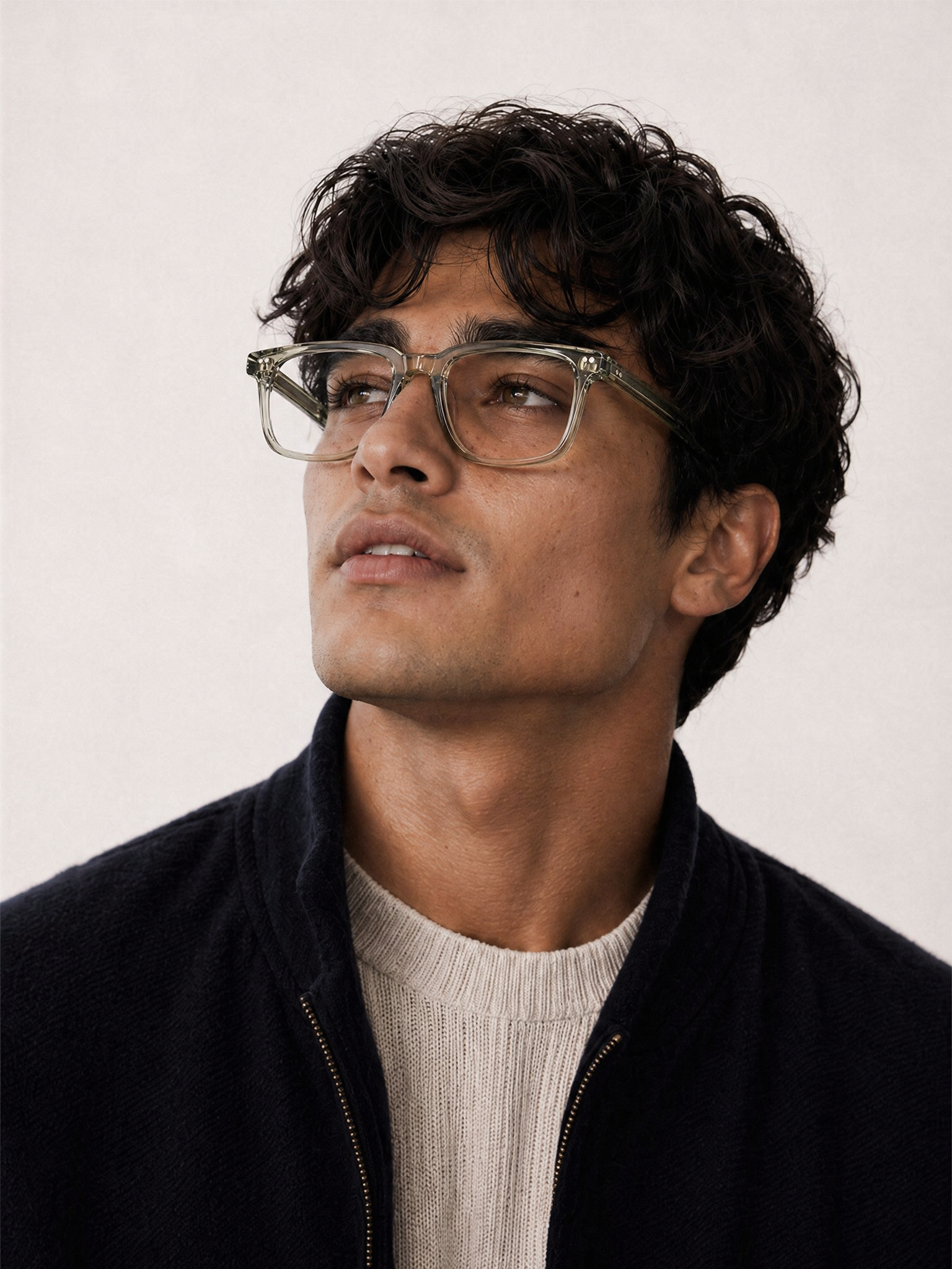 Man wearing blue light glasses VERA model and a dark jacket against a plain background