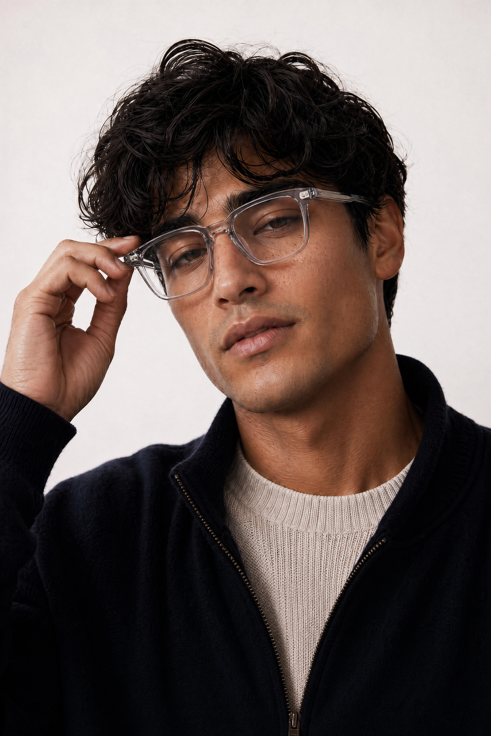 Man adjusting blue light glasses model VERA against a plain background